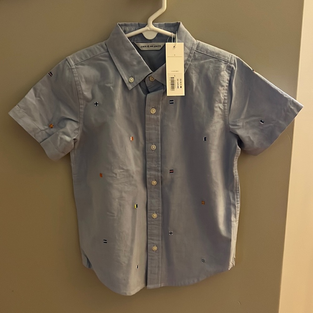Never worn boys size 6 light blue, nautical flag button up short sleeved shirt.